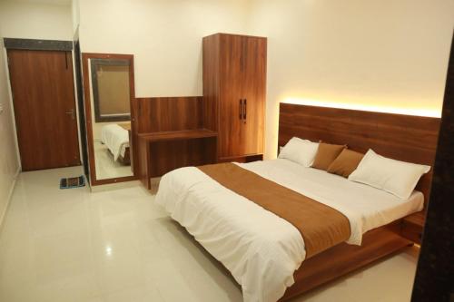 a bedroom with a large bed and a mirror at The Mukhiya Palace in Govardhan