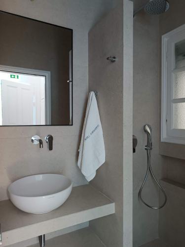 a bathroom with a white sink and a mirror at Paraporti in Chora Folegandros