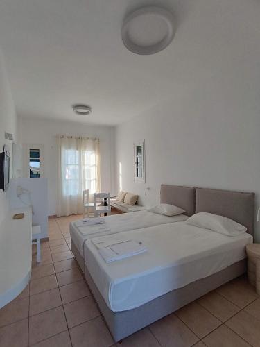 a bedroom with two beds and a living room at Paraporti in Chora Folegandros