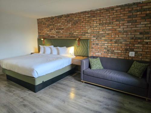 a bedroom with a bed and a couch at Penn Lodge Hotel & Suites Philadelphia - Bensalem in Bensalem