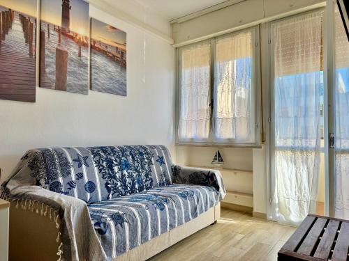 a living room with a couch and some windows at Alabastro 40 in Lido Adriano