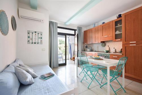 a kitchen and living room with a table and chairs at Piccolo Loft Sabbia e Sassi in Marina di San Vito