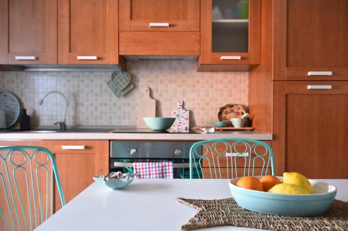 a kitchen with wooden cabinets and a bowl of fruit on a counter at Piccolo Loft Sabbia e Sassi in Marina di San Vito