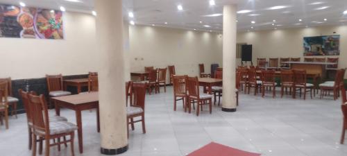 a dining room with wooden tables and chairs at Mathios Hotel & Menafesha in Butajīra