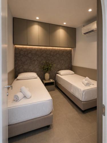 a bedroom with two beds with towels on them at Green Coast Escape in Palasë