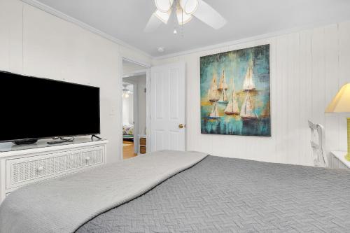 a bedroom with a bed and a tv on a wall at Sunkissed 2 by Oak Island Accommodations in Oak Island
