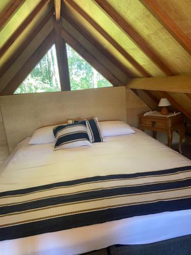 a bed in a attic room with a window at Villa da Serra in Águas da Prata
