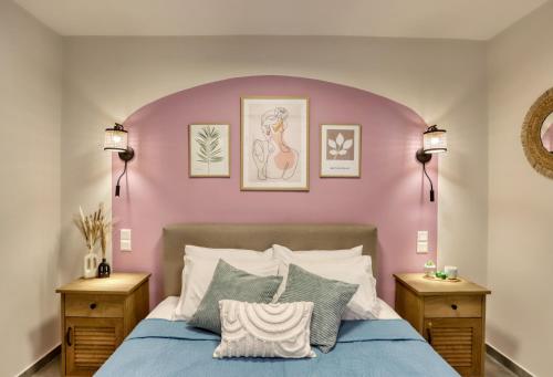 a bedroom with a pink headboard and a bed with pillows at Eftychia's Cozy Apartment in Sitia