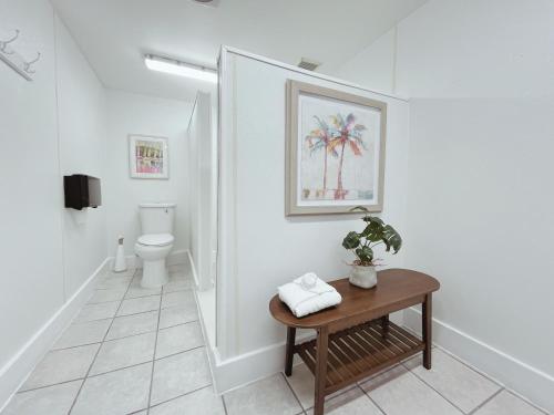 a white bathroom with a toilet and a table at Blackfin Resort and Marina in Marathon