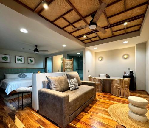 a bedroom with a bed and a couch and a table at Musa Hotel Boutique in Bucerías
