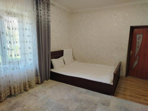 a small bed in a room with a window at Sayora Guest House in Khorugh
