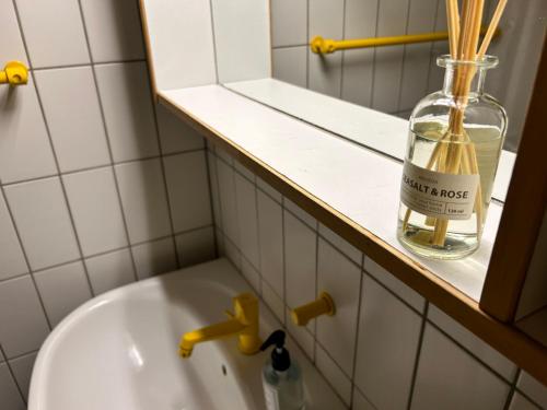 a bathroom with a bottle on a shelf next to a sink at Overnatning med plads til mange in Holstebro