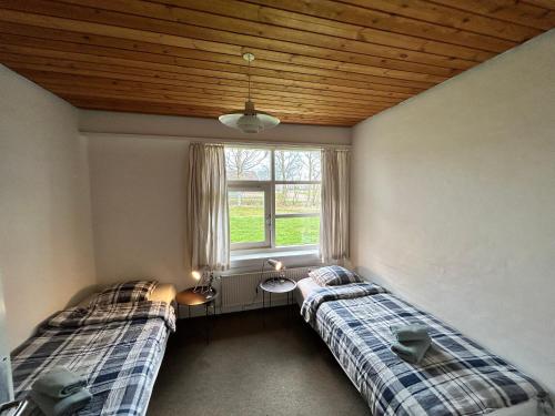 two beds in a room with a window at Overnatning med plads til mange in Holstebro