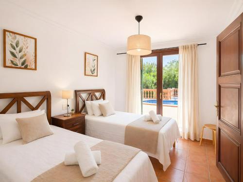 a hotel room with two beds and a balcony at Son Grau in Alaró