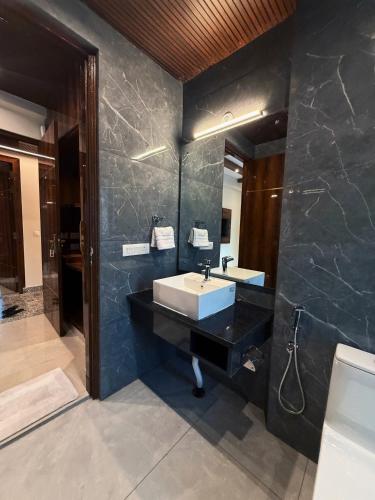 a bathroom with a sink and a large mirror at Kesari Hotel & Restaurant Near Kainchi Dham in Rāmgarh