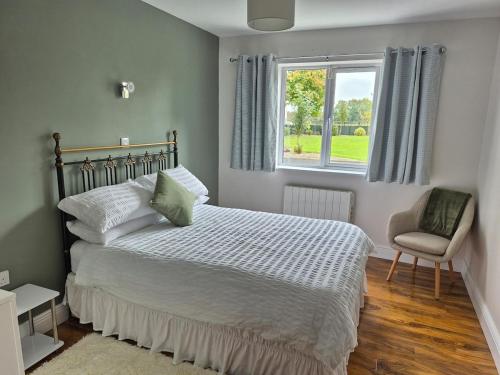a bedroom with a bed and a window and a chair at Guest Suite in County Limerick in Pallaskenry