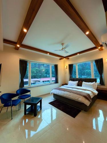 a large bedroom with a large bed and some windows at Kesari Hotel & Restaurant Near Kainchi Dham in Rāmgarh