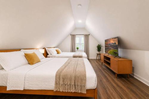 a bedroom with two beds and a television in it at Cozy Home near Downtown - Close to Nulu - Sleeps 6 in Louisville
