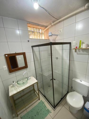a bathroom with a glass shower and a toilet at quintal293 in Recife
