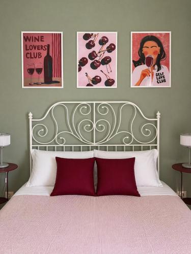 a bedroom with a bed with three pictures on the wall at Atenè Rooms in Agrigento