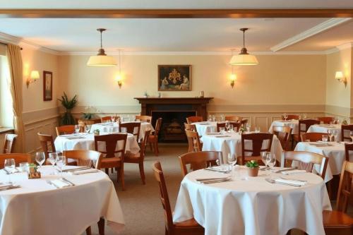 a dining room with white tables and chairs at Hotel zur Lichtenburg in Ostheim