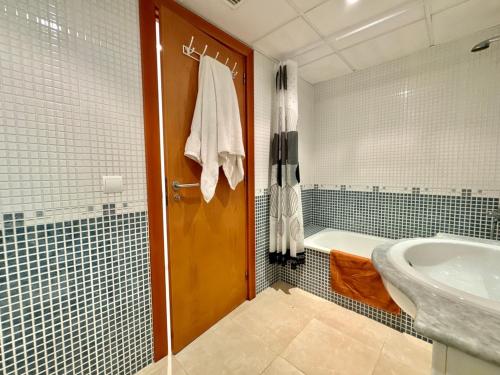 a bathroom with a tub and a toilet and a sink at Brisa del Delta & Pool in L'Eucaliptus