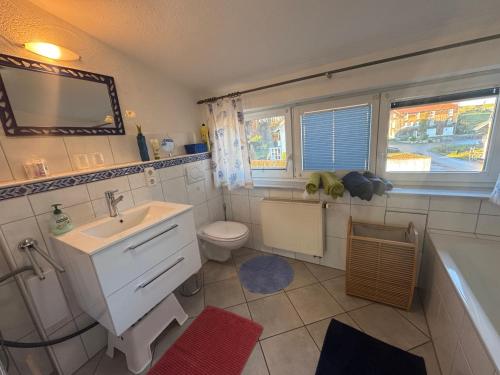 a bathroom with a sink and a toilet and a tub at Sonniges Familien-Nest im Allgäu in Hergatz