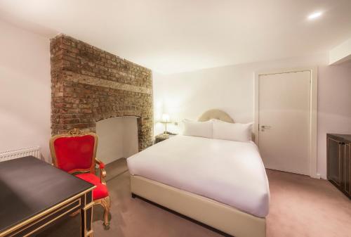 a bedroom with a white bed and a red chair at Nottingham Place Hotel in London