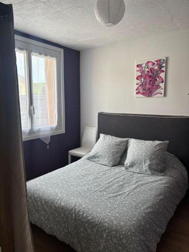 a bedroom with a bed and a window at Ma petite maison in Vierzon