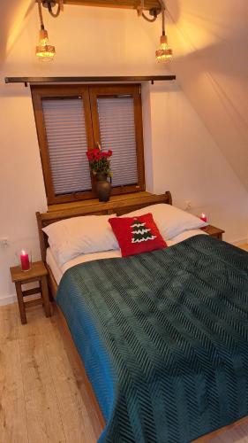 a bedroom with a large bed with a window at Domek Julia in Krościenko