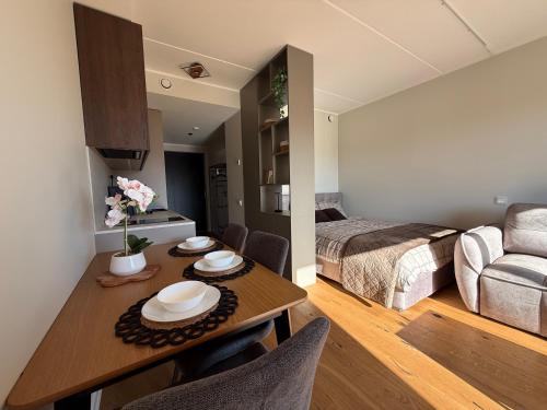a room with a dining table and a bedroom at Nameja Apartamenti in Riga