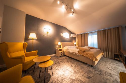 a bedroom with a bed and a chair and a table at Complex Rediu 54 Luxury Apartaments in Iaşi