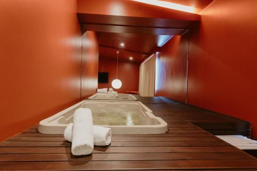 a bathroom with a tub with towels on a wooden floor at Hotel Belisario in Medellín