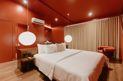 a bedroom with a large bed with red walls at Hotel Belisario in Medellín
