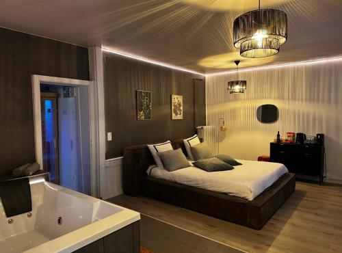 a bedroom with a bed and a bath tub at La suite 44 in Le Locle