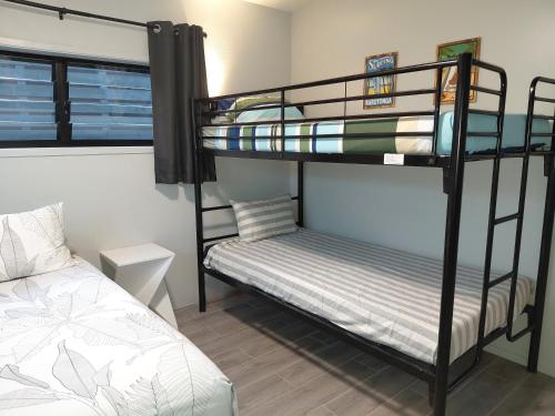 a bedroom with two bunk beds and a bed at Pool Villa No 10 in Rarotonga
