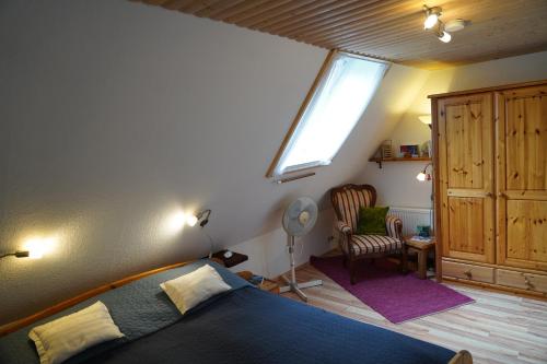 a bedroom with a bed and a window and a chair at Nordseerex in Ahrenshöft