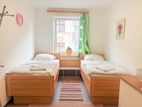 two beds in a room with a window at Beenie 3 in Linz