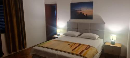 a bedroom with a bed with two lamps on it at Batea 1 in Seline