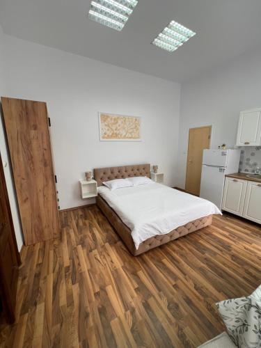 a bedroom with a bed and a wooden floor at November Central Studio in Lugoj