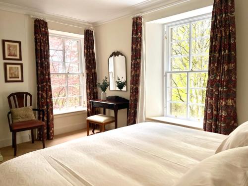 a bedroom with a bed and a desk and a window at The Coach House in Stirling