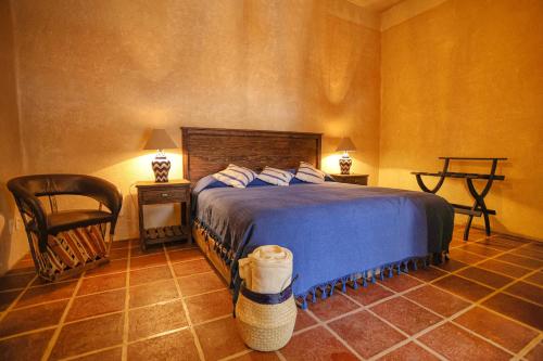 a bedroom with a bed and a chair and a table at Hotel Oviedo Teotihuacán in San Martín de las Pirámides