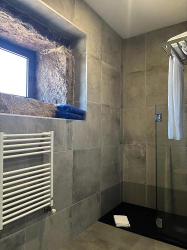 a bathroom with a shower with a blue hand on the wall at Quinchoso dos Bentos in Vila Pouca de Aguiar