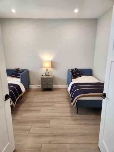 a room with two beds and a lamp on a table at Prettiest town's lake- Bungalow in Goderich