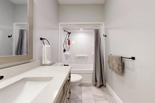 a white bathroom with a sink and a toilet at Prettiest town's lake- Bungalow in Goderich