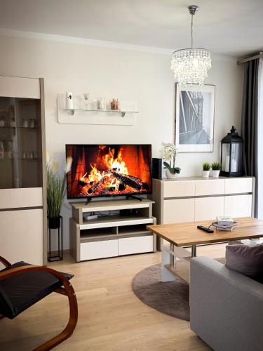 a living room with a tv and a fireplace at Apartament Orange Piastowska in Ostróda