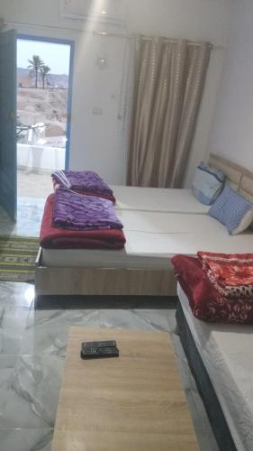 two beds in a room with a remote control on the floor at dar fatma matmata in Matmata