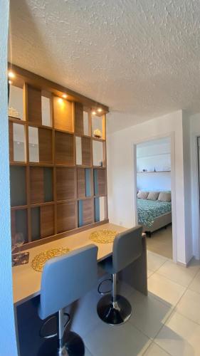 a room with a desk and two chairs and a bed at Aconchego Perto das praias da região oceânica in Niterói