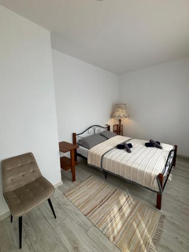 a bedroom with a bed and a chair at Vecpilsētas apartaments in Cēsis