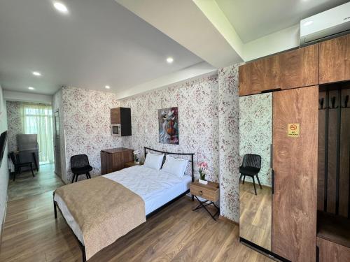 a bedroom with a bed and a desk and two chairs at Airport Hotel Apartments in Tbilisi City